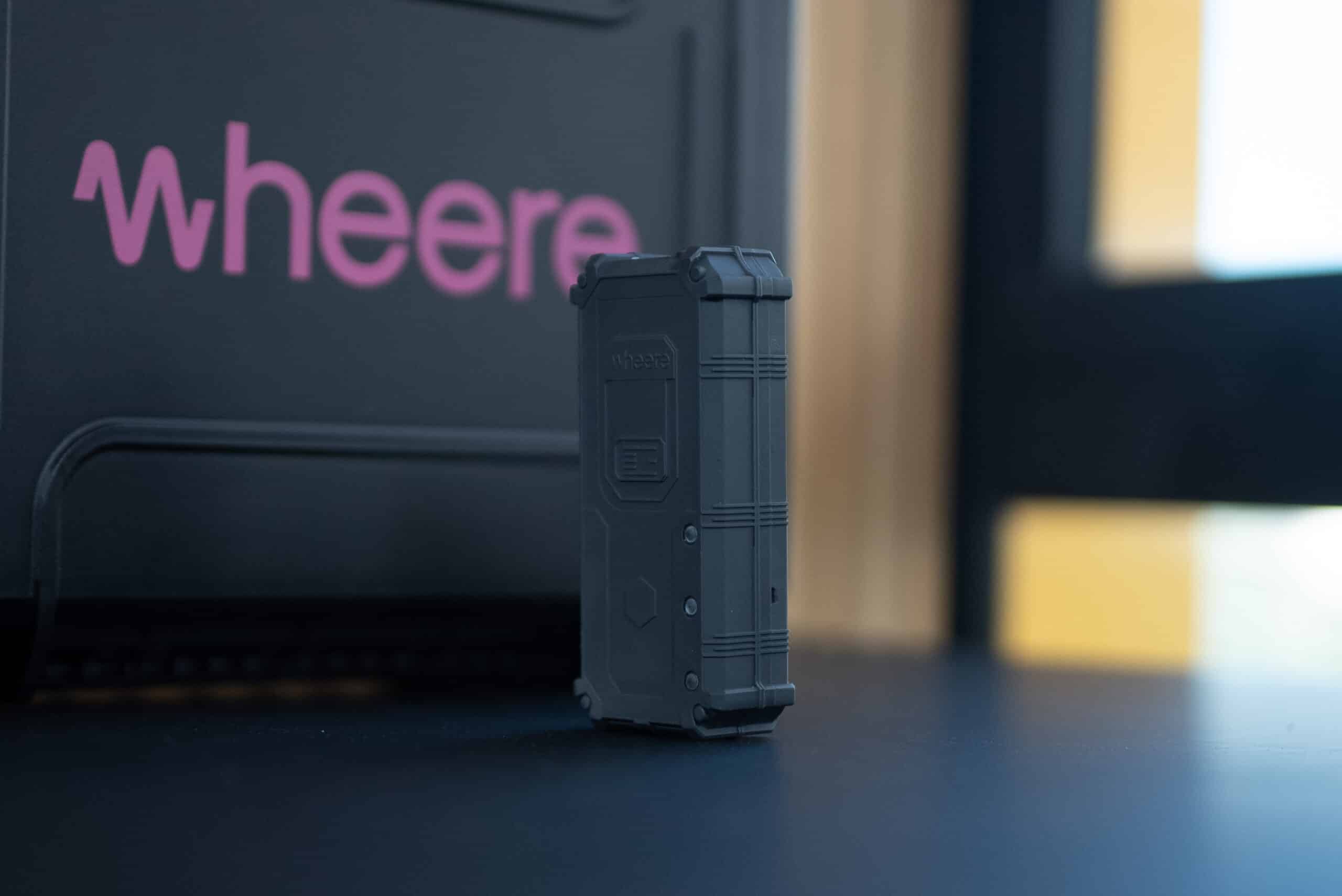 photo du tracker de géolocalisation indoor PTI Wheere, avec en arrière plan, la valise de chargement Wheere